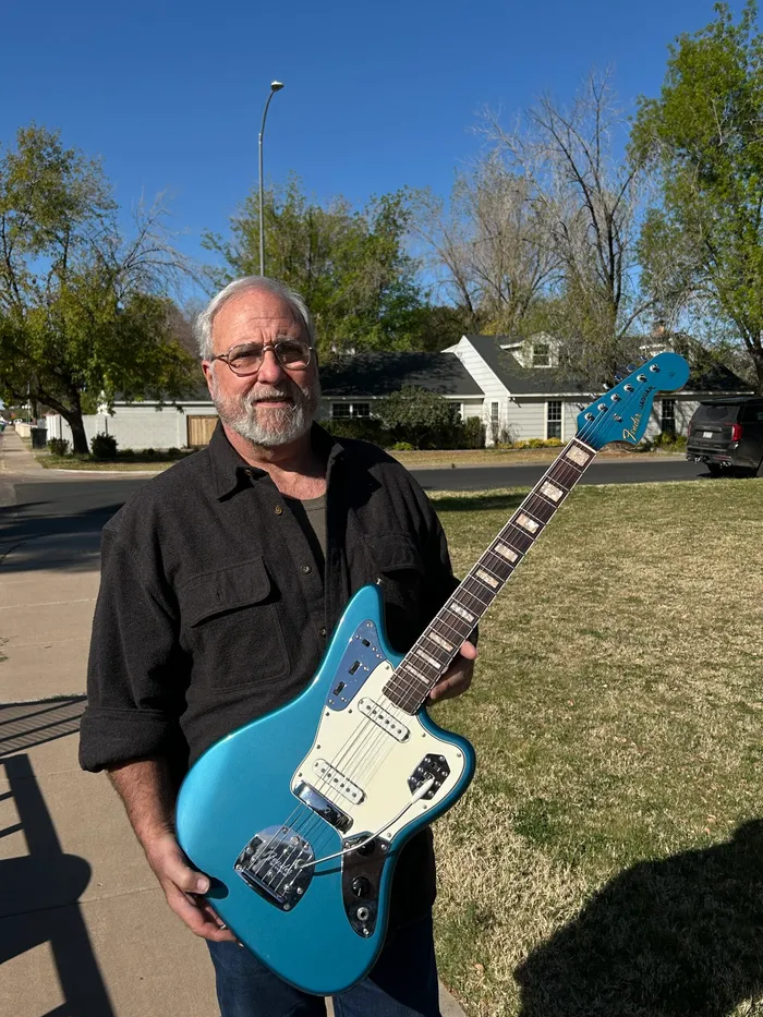 Bill holding the Lake Placid Blue 1966 Fender Jaguar his father bought for him when he was young