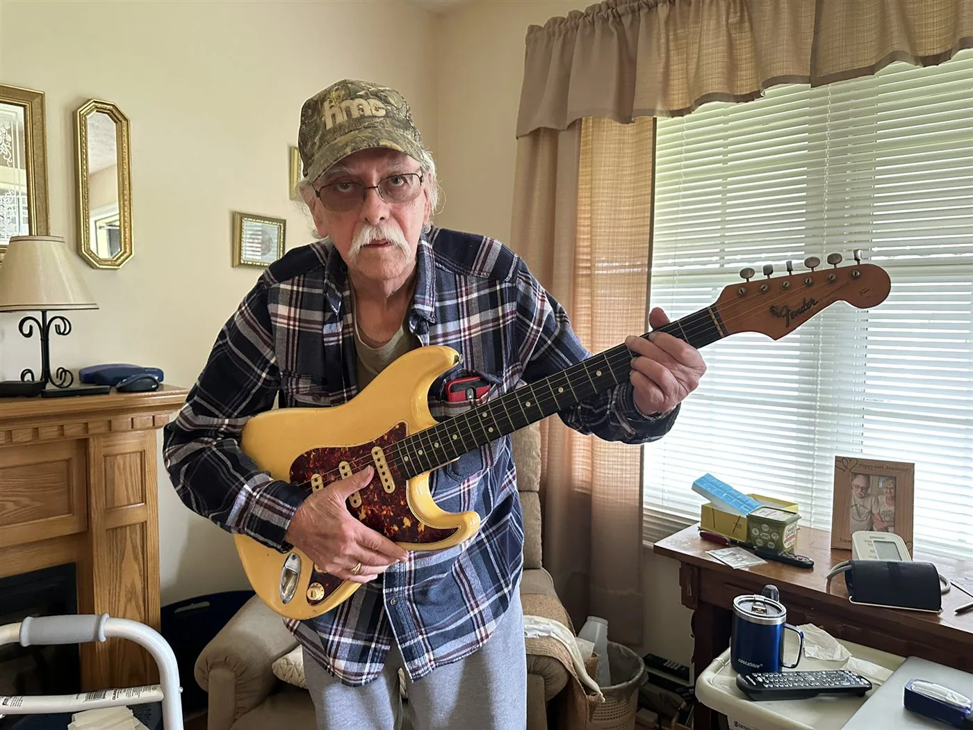 The original owner holding his 1965 Olympic White Fender Stratocaster with its factory tortoise pickguard